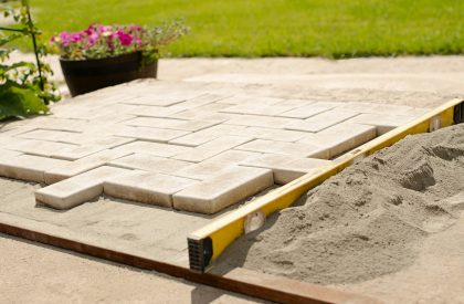 The master lays paving stones in layers. Garden brick pathway paving by professional paver worker. The master lays paving stones in layers. Garden brick pathway paving by professional paver worker.