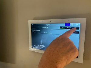 A woman manages her irrigation or sprinkler system from her smart home panel