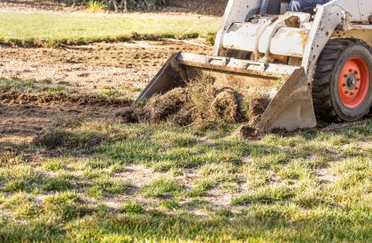 Small Bulldozer Removing Grass From Yard Preparing For Pool Installation Small Bulldozer Removing Grass From Yard Preparing For Pool Installation